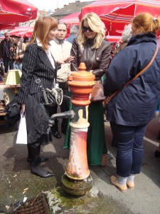 Locals gather around the water pump to chat